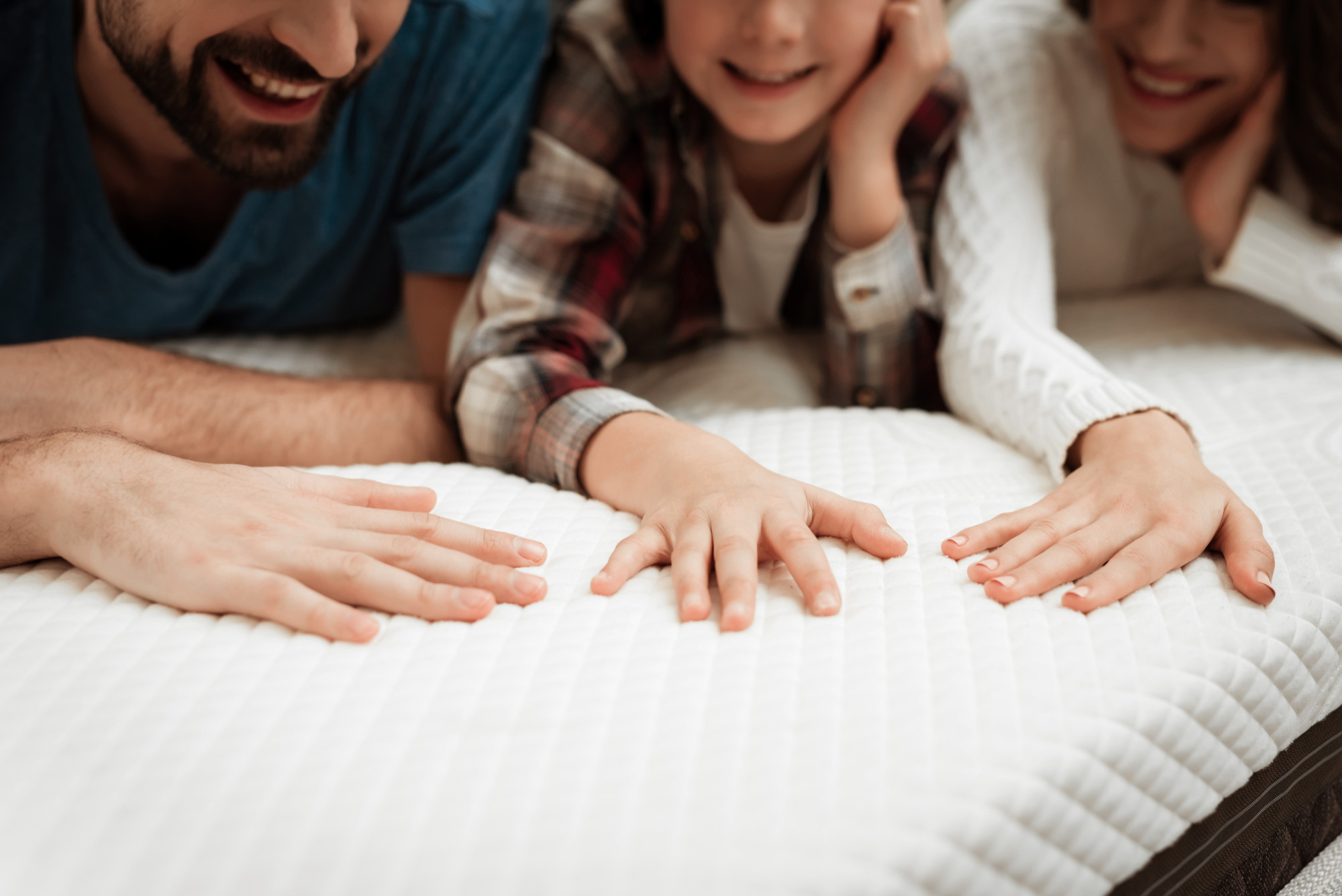 closeup happy family touching mattress store Long Lasting Mattresses Long Lasting Mattresses,Unbeatable Comfort,Local Mattress Distributor,resistant materials WHY CHOOSE US - Long lasting mattresses