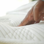 hand touching pressing orthopedic mattress bed 1 What Causes Mattress Sagging and How to Prevent It